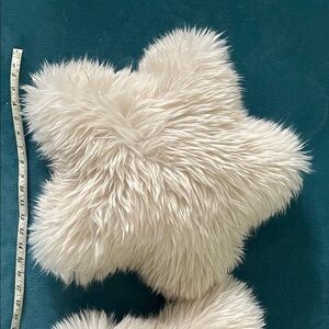 A pair of Pottery Barn pillows.  Plush Star-Shaped Faux Fur Pillow in Cream